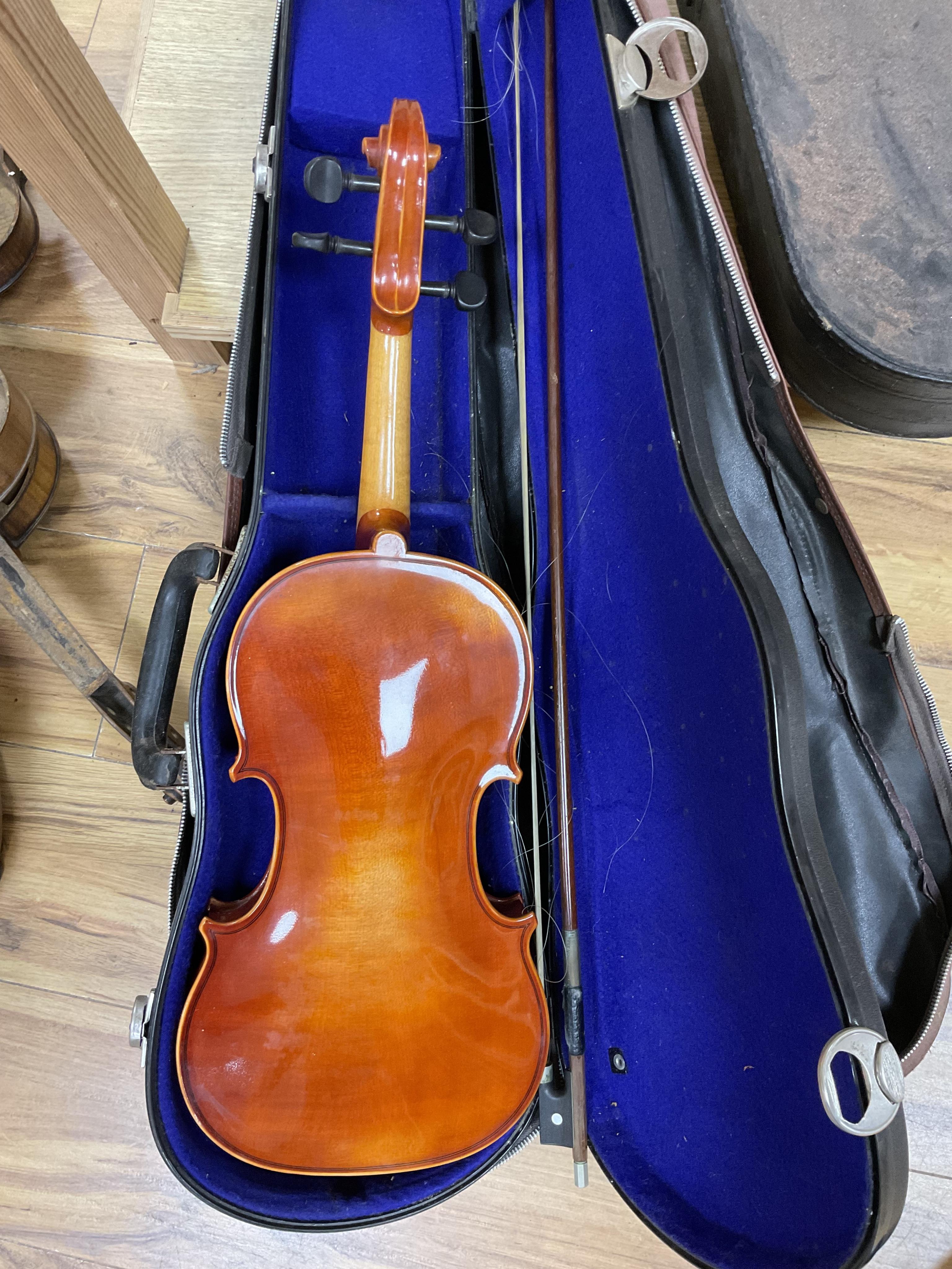 A quantity of violin parts and violins, a ukelele, a double bass scroll, a pinfold metronome, a violin case by Hill, a viola etc. Condition - for restoration